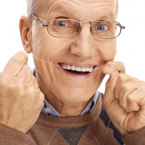 Mature man flossing his teeth